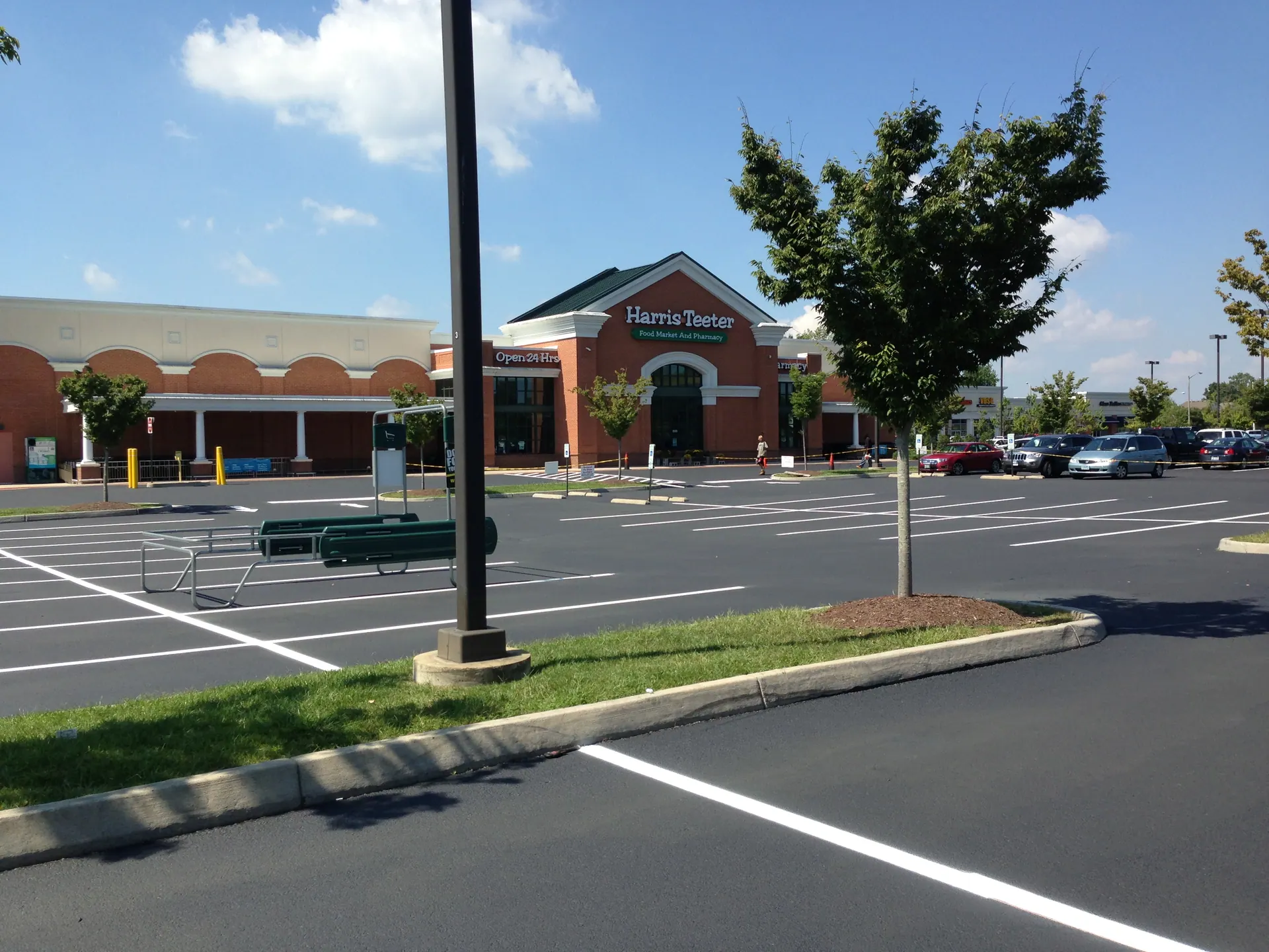 Crisp new stripes on jet-black sealcoat at a grocery-anchor lot